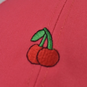 Front view of red cotton baseball cap featuring high-quality cherry fruit embroidery