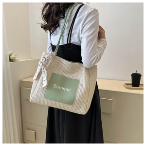 Détail du sac cabas en paille tissée avec patch Summer vert et foulard floral décoratif