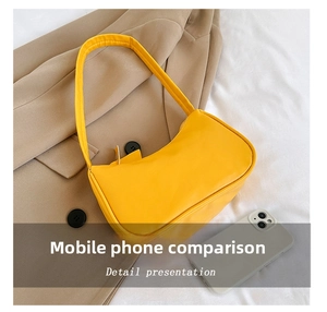 Detail presentation of yellow faux leather shoulder bag next to a smartphone for size comparison