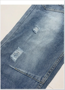 Detail van de gewassen blauwe denim textuur en scheuren op de wijde banana jeans