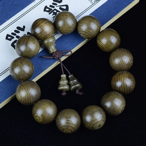 Macro detail of aged Phoebe zhennan wood beads with natural grain and gourd charm