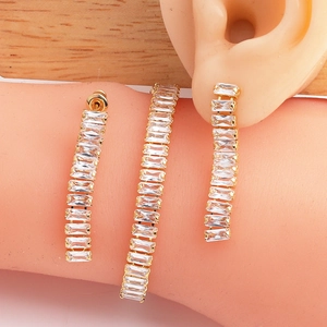 Close-up of elegant gold plated cubic zirconia earring and bracelet set on female model