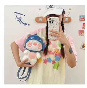 Detail of plush cat doll backpack with soft blue hood and pink accents on model