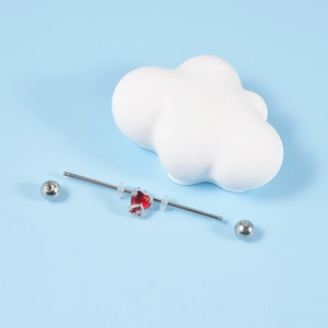 Macro detail of industrial barbell with red heart zircon and steel flower drop design