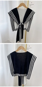 Close-up of black and white striped knit shawl wrap with tie-up detail for women