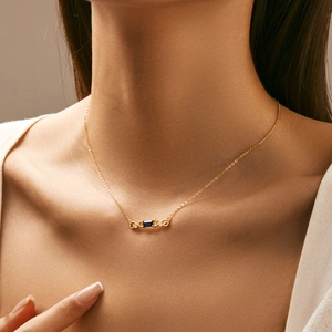 Elegant gold necklace with rectangular blue gemstone pendant worn on neck