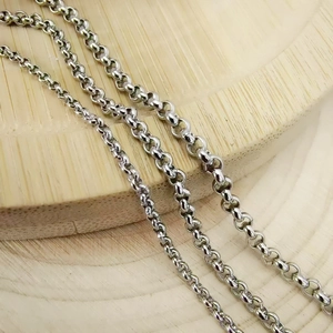 Polished stainless steel chain link necklaces in three sizes on a wooden display base