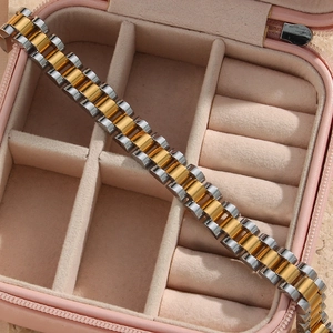 Detail view of two-tone gold and silver watch-band style bracelet in a pink jewelry box