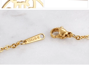 Macro detail of a bright gold stainless steel lobster clasp on a Mama jewelry necklace