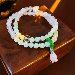 Detail of beaded bracelet with green jade peace buckle and pink lily of the valley charm