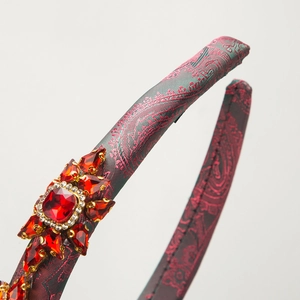 Baroque padded headband with red rhinestone floral jewels and paisley fabric texture