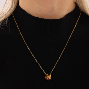 Three-ring layered gold necklace with colorful zircon stones on black background