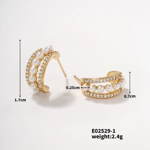 Détail de boucles d'oreilles dorées de 1,7cm avec trois rangées de perles et zircons