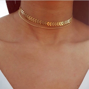 Close-up of golden double-layered choker necklace with fishbone chain on a model