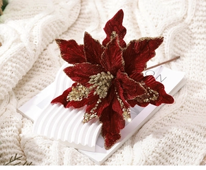 Vue détaillée du poinsettia en velours rouge foncé avec bords pailletés dorés pour sapin