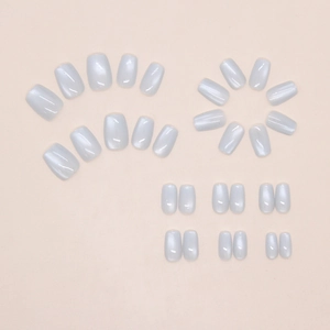 Detailed flat lay of 24 light grey cat eye press-on nails in various sizes and square oval shape