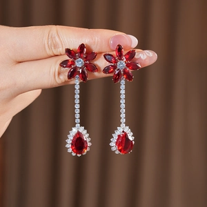 Detailed close-up of vintage flower drop earrings with red crystals and diamond chains