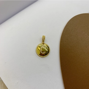 Macro detail of a 18K gold plated letter C apple pendant with micro-set zircon stones
