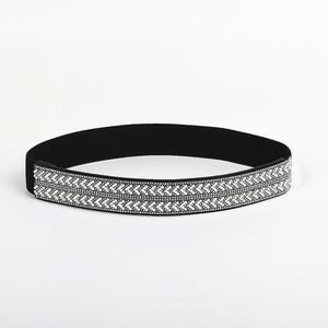 Close-up of flexible wide waist belt with double row V-shaped rhinestones on black fabric