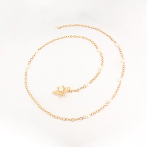 Detail of bee pendant with large pearl and woven gold chain featuring white pearl accents