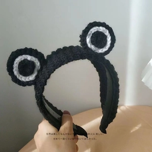 Handgestricktes schwarzes Stirnband mit großen Froschaugen und rutschfesten Innenzähnen