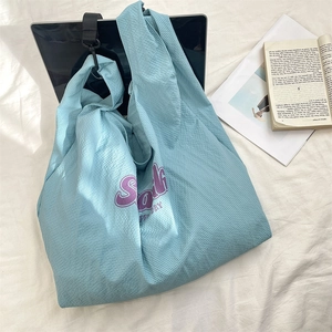 Détail du sac fourre-tout à carreaux bleu clair avec imprimé Smile sur un ordi