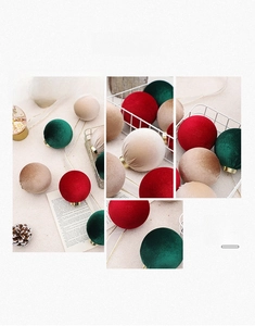 Close-up of velvet Christmas balls in red and green with gold hanging loops on festive background