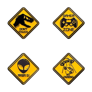 Set of 4 yellow enamel pins featuring dinosaur, alien, UFO and gamer zone warning signs