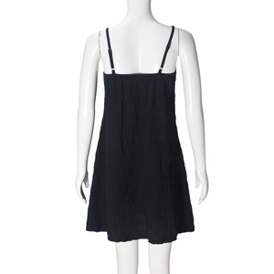 Detail view of the black knit pleated mini dress showing backless design on a mannequin