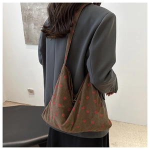 Close-up of brown corduroy tote bag with red strawberry pattern and soft velvet texture