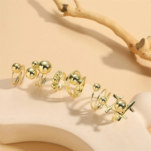 Set of six gold minimalist rings featuring beaded and geometric spiral designs on stand