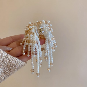 Detail of elegant faux pearl and champagne faceted bead tassel hair claw clip