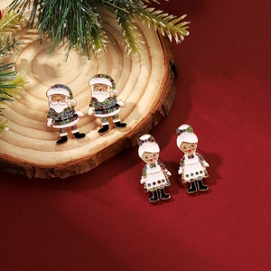 Detail of Christmas earrings featuring Santa motifs with colorful rhinestones on wood decor