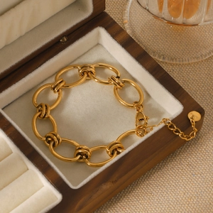 Detail of chunky gold stainless steel chain bracelet with knots and a lobster clasp