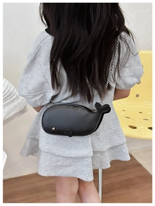Rear view of a child wearing a cute black whale crossbody bag with silver chain