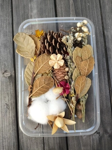 Detailed top view of DIY Christmas floral kit with pine cones, cotton, and dried leaves