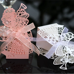 Laser-cut angel favor boxes in pink and white pearlescent paper with organza ribbons