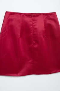 Close-up of elegant red satin skirt featuring premium silk texture and seamless finish
