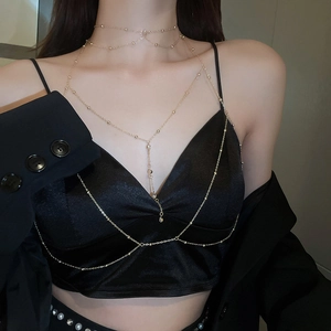 Vue détaillée d'une chaîne de corps dorée élégante avec perles portée par un mannequin