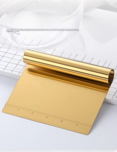Macro detail of golden stainless steel dough scraper featuring precise laser scale markings