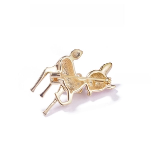 Detail view of the golden deer brooch back with safety pin clasp and textured metal