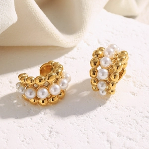 Detail of C-shaped 18K gold plated earrings featuring triple rows of pearls and beads