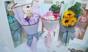 Detailed view of varied colorful soap flower bouquets with cute bear charm and ribbons