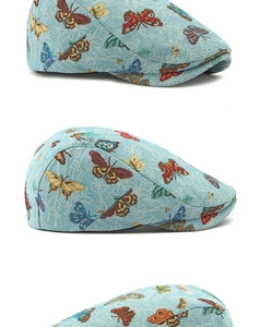Detail van groenblauwe platte pet met levendig jacquardpatroon van vlinders
