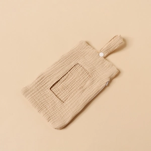 Detail of baby wipes storage bag with cream cotton texture and hanging button strap