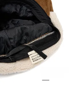 Detail of winter beret featuring faux suede, fleece lining and adjustable velcro strap
