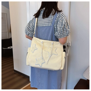 Dettaglio della borsa in velluto a coste giallo chiaro con carine stelle blu applicate