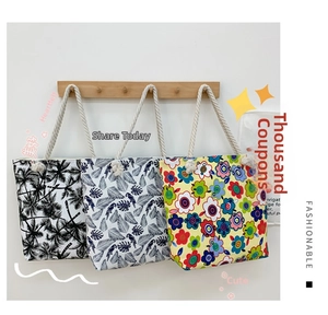 Three canvas tote bags with floral prints and cotton rope handles on wooden wall hooks