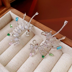 Close-up of gemstone cluster wing ear cuff with blue and pink stones in wood box