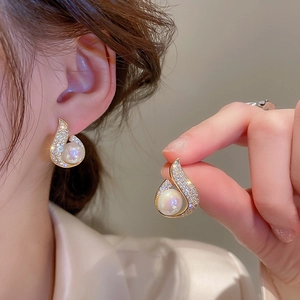 Detail of fishtail pearl earrings with gold plating and zircon teardrop design